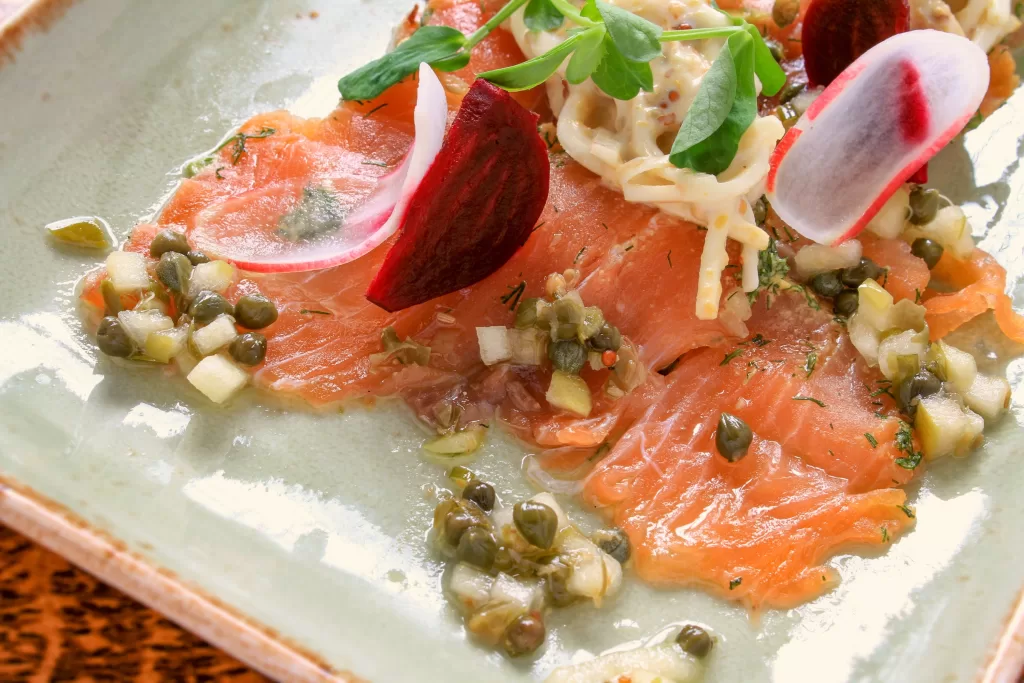 O gravlax é um prato tradicional à base de salmão cru curado por alguns dias em uma mistura de sal, açúcar e bastante endro (dill). 