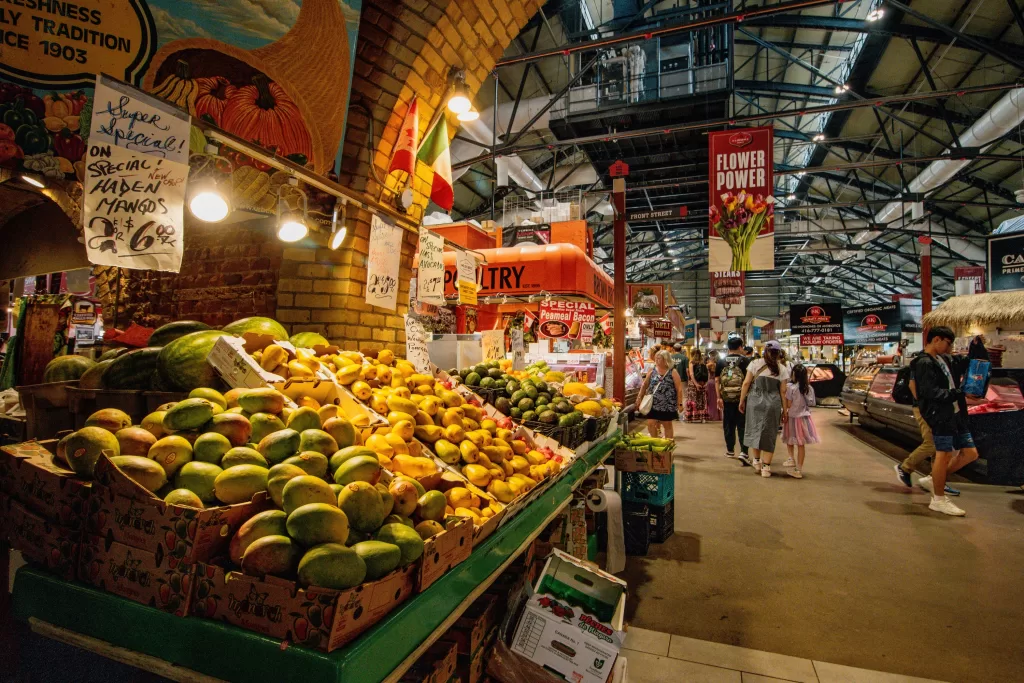 St. Lawrence Market: o coração gastronômico de Toronto. É o lugar ideal para provar o tradicional sanduíche de peameal bacon e explorar barracas de produtos frescos e artesanais.