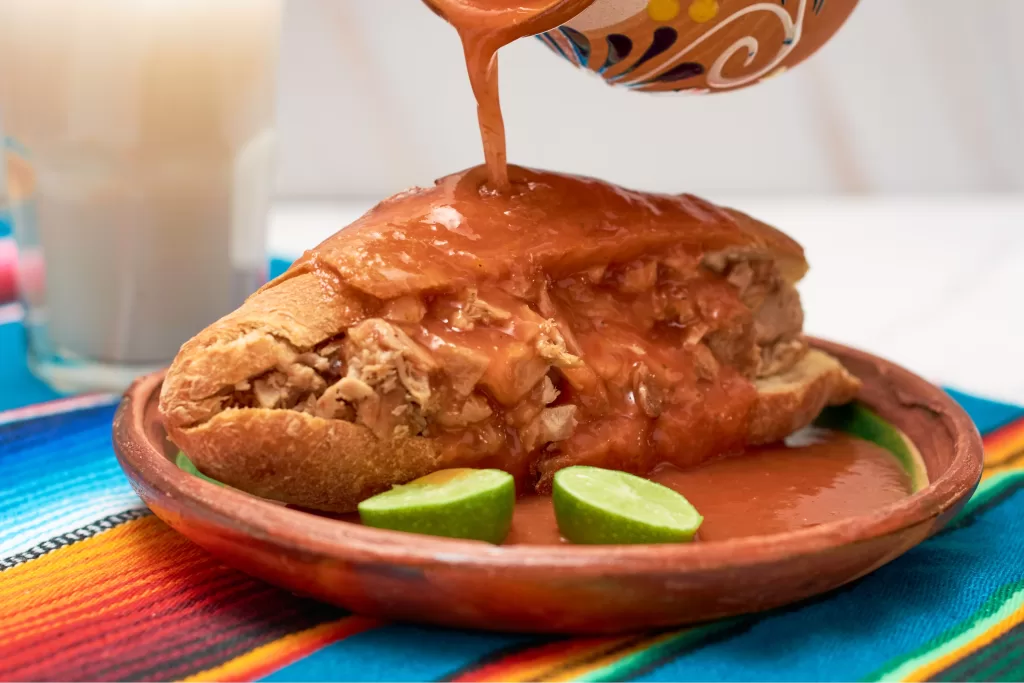 A torta ahogada é o prato mais famoso de Guadalajara. Consiste em um sanduíche de carne de porco (carnitas) em um pão crocante chamado birote, que é literalmente mergulhado em um molho de tomate e pimenta.