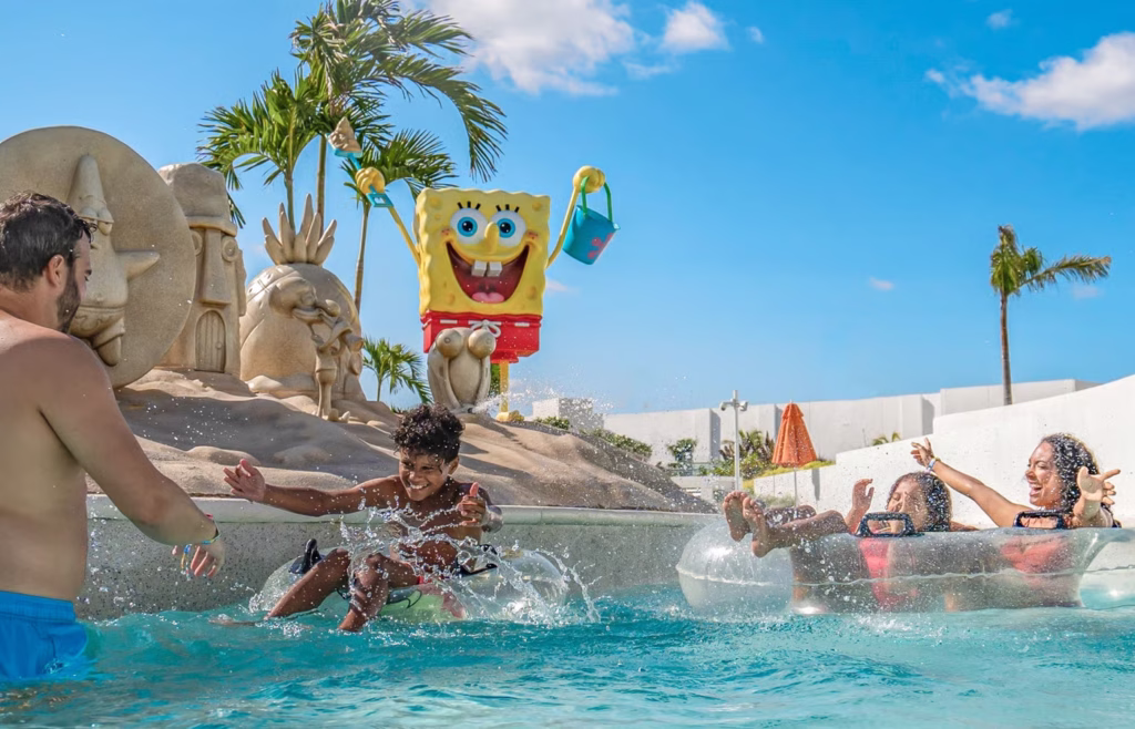 Família se divertindo em boias no rio lento do Nickelodeon Hotels & Resorts Riviera Maya, com estátua do Bob Esponja, em viagem ao México com crianças.